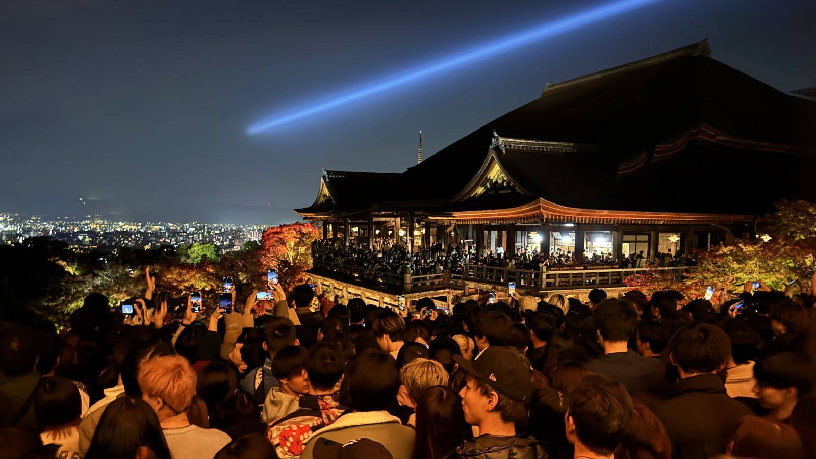 Kiyomizu-dera Temple illuminated above autumn foliage.