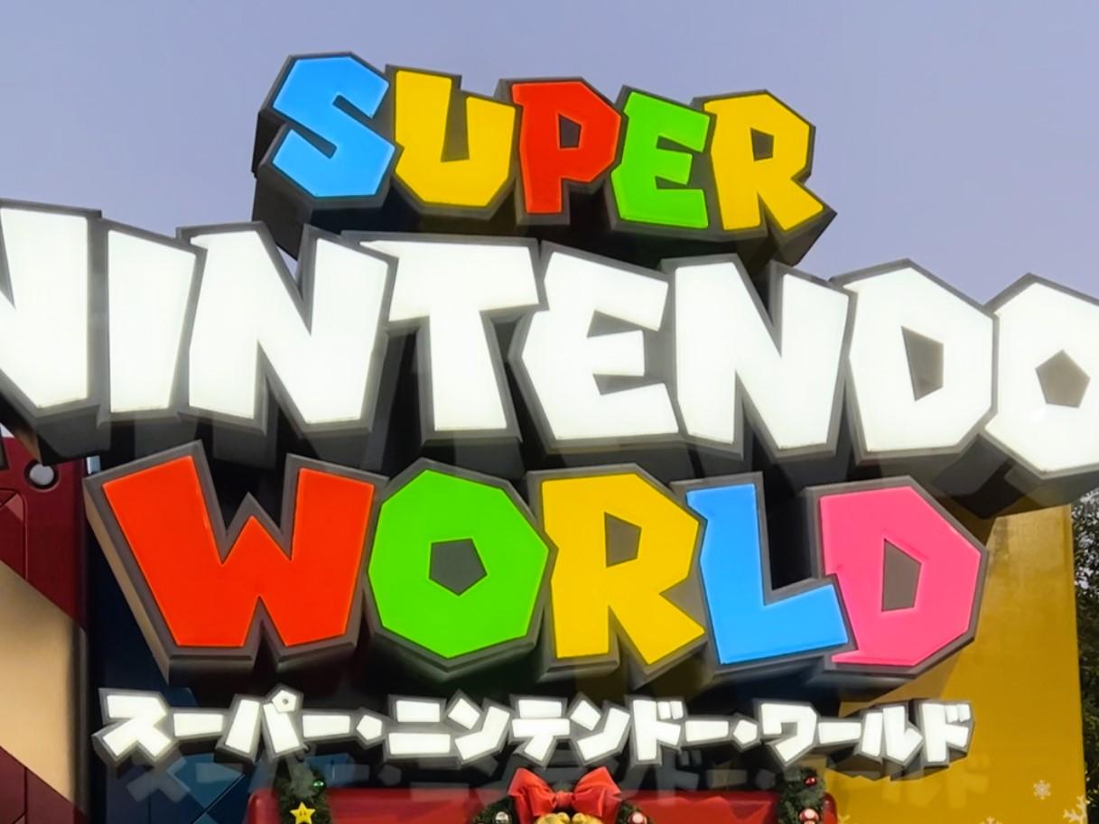 Bright multi-colored Super Nintendo World entrance marquee sign with English and Japanese text at Universal Studios Japan (USJ), Osaka.